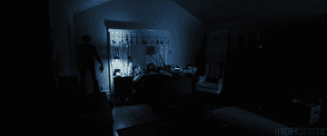 A shadow points at a child in a bed