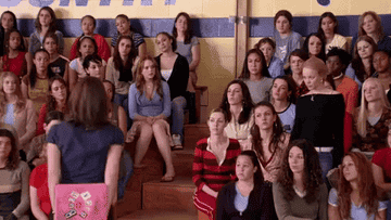 A crowd of high school girls raising their hands