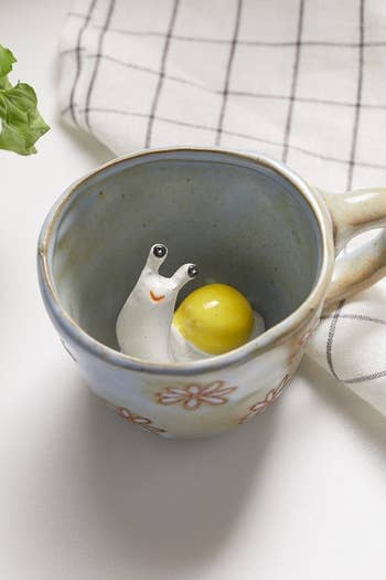 the snail peekaboo mug with a cute snail sculpture at the bottom of the mug