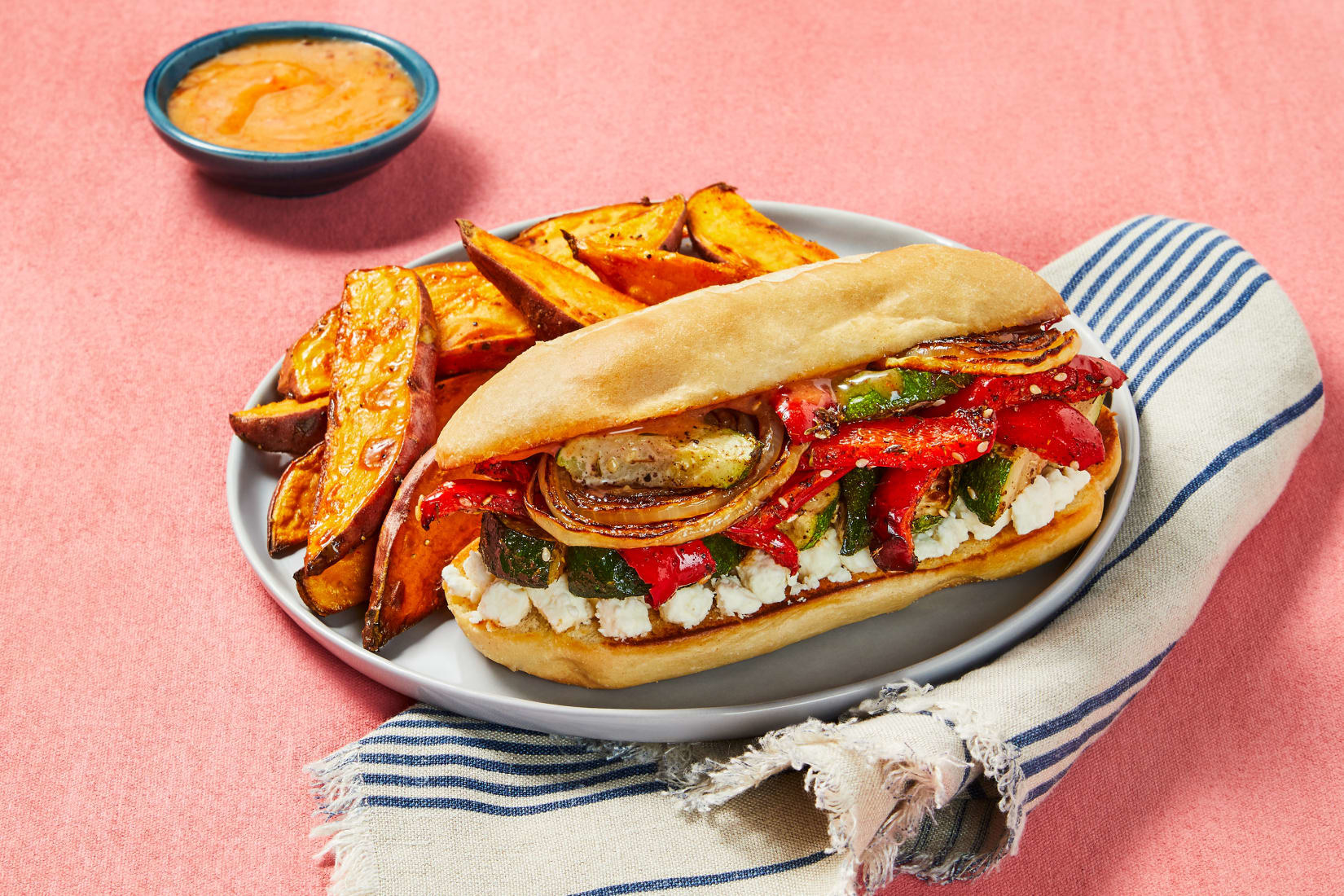 A plated final image of Za’atar-Roasted Zucchini &amp;amp; Pepper Sandos with wedge fries