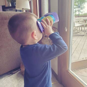reviewer's child holding the binoculars and looking out of the window