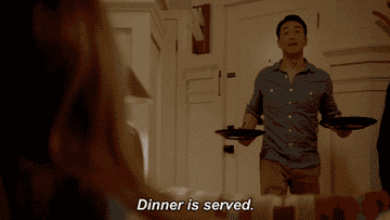a gif of actor Kenneth Choi in the show &quot;9-1-1&quot; carrying two plates, bowing, and saying &quot;Dinner is served&quot;