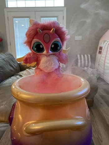 A stuffed animal emerging from a pot surrounded by pink mist
