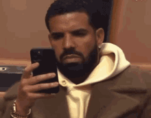 Drake staring at his cellphone