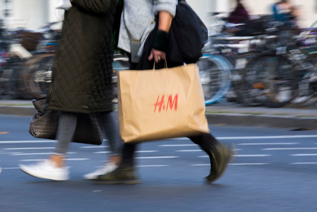 Person walking with H&amp;amp;M bag across the street