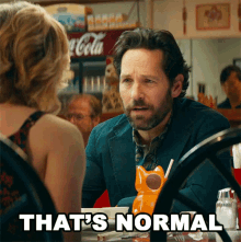 Paul Rudd sitting at a restaurant table and saying to a woman, &quot;That&#x27;s normal&quot;