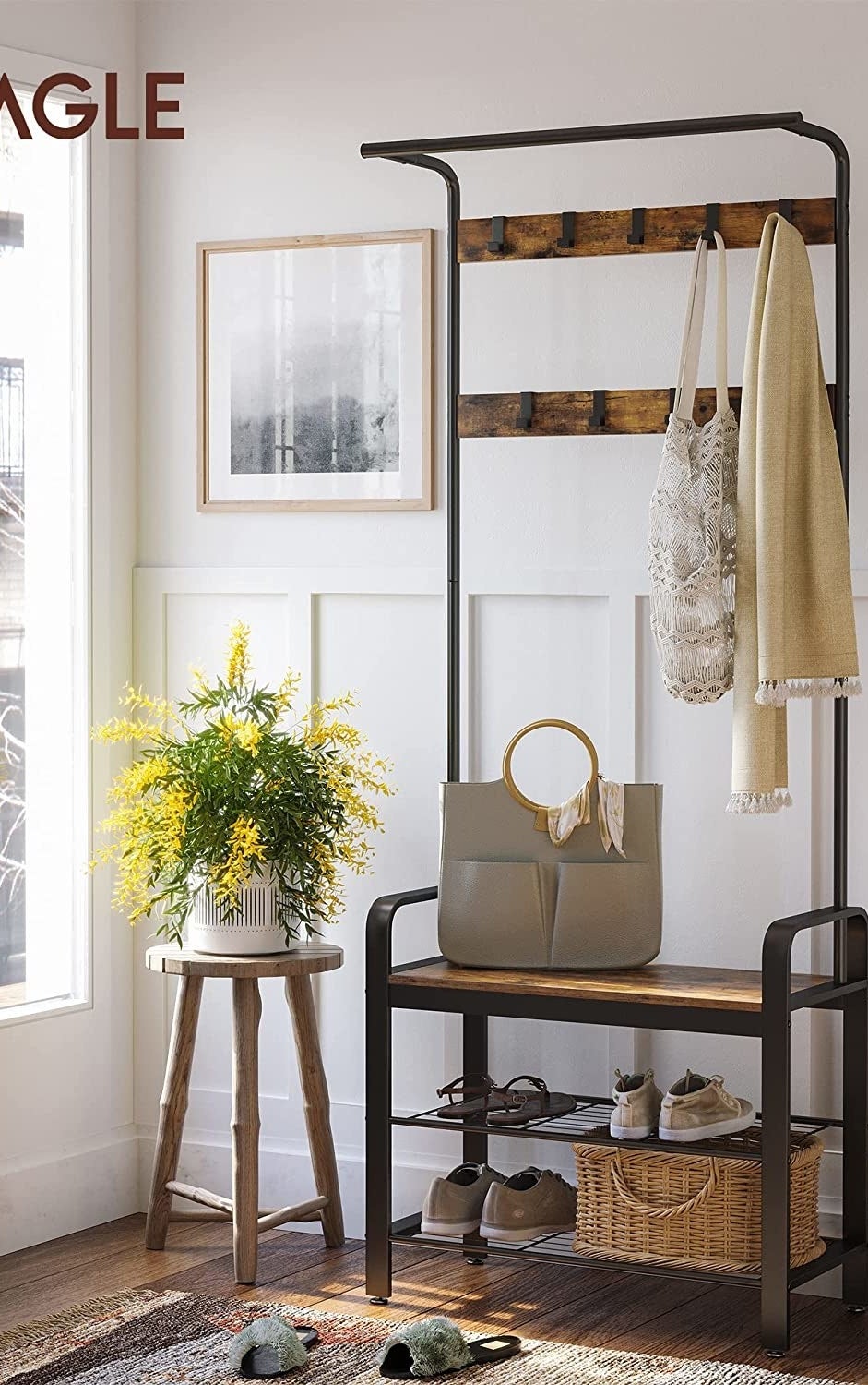 The coat rack with shoes, a tote bag, and some scarves hanging from it, next to an accent table with a plant on it
