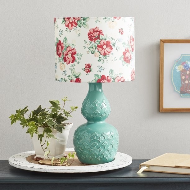 An image of a table lamp with a floral lampshade