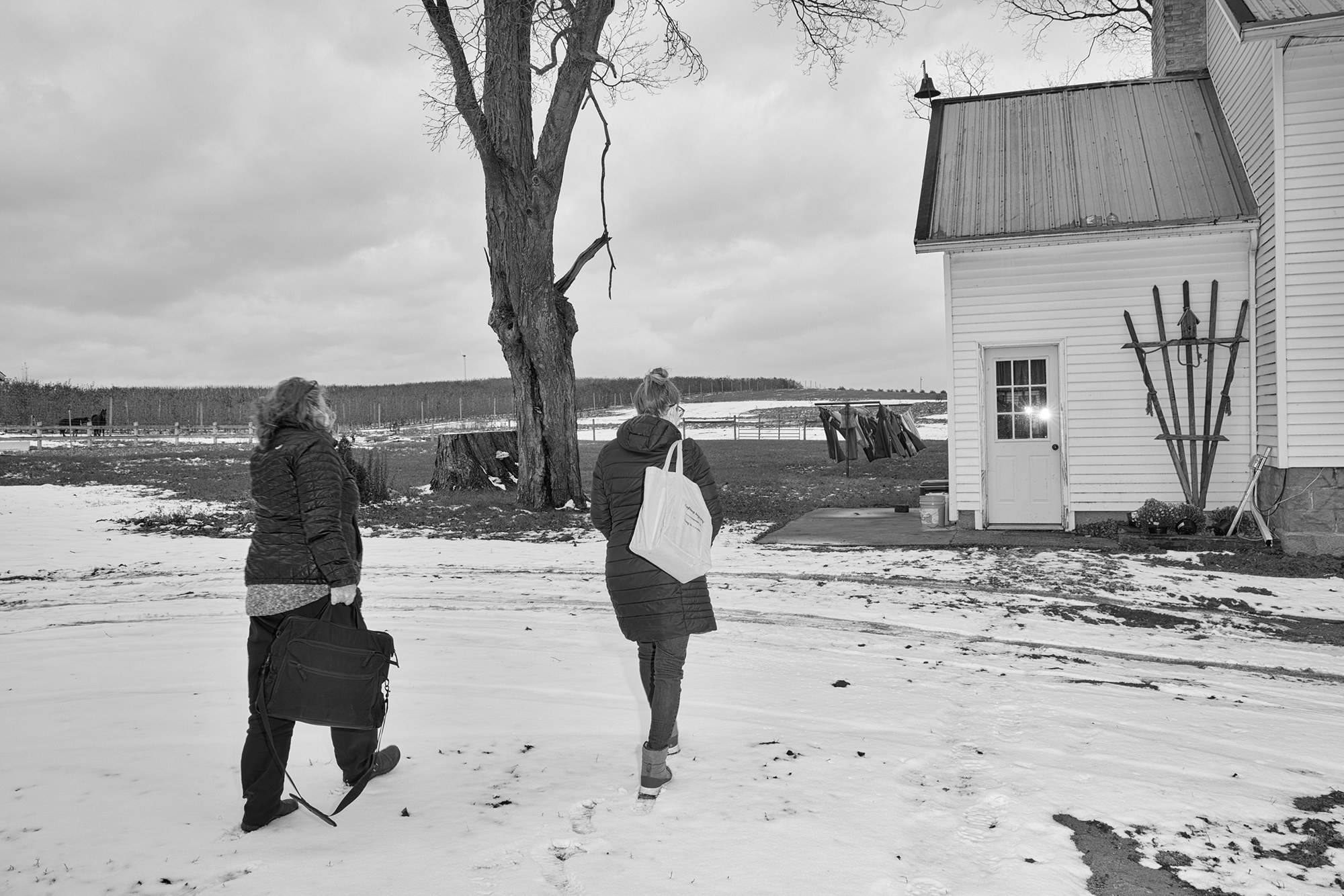 Two midwives walk into a house on a snowy plain