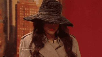 Gif of a woman wearing sunglasses and a hat.
