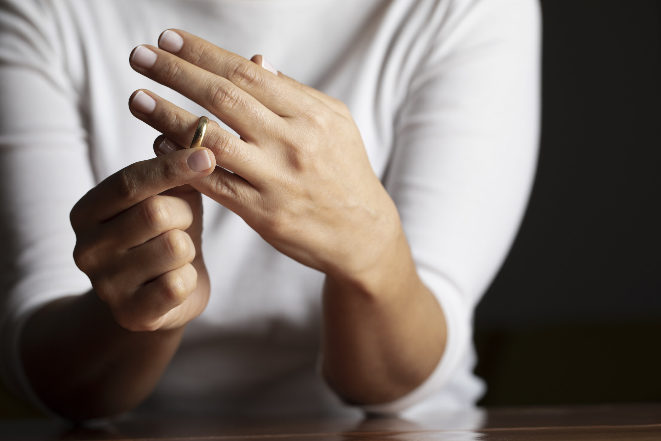 Hands take a wedding ring off