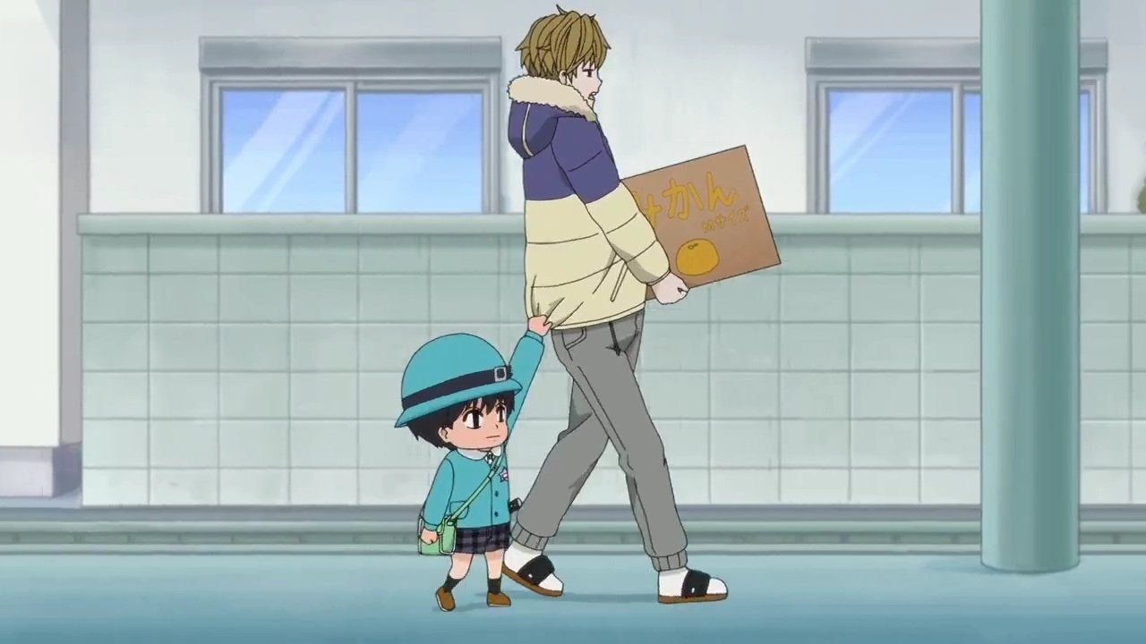 little boy holding onto coat tails of man holding box of oranges 