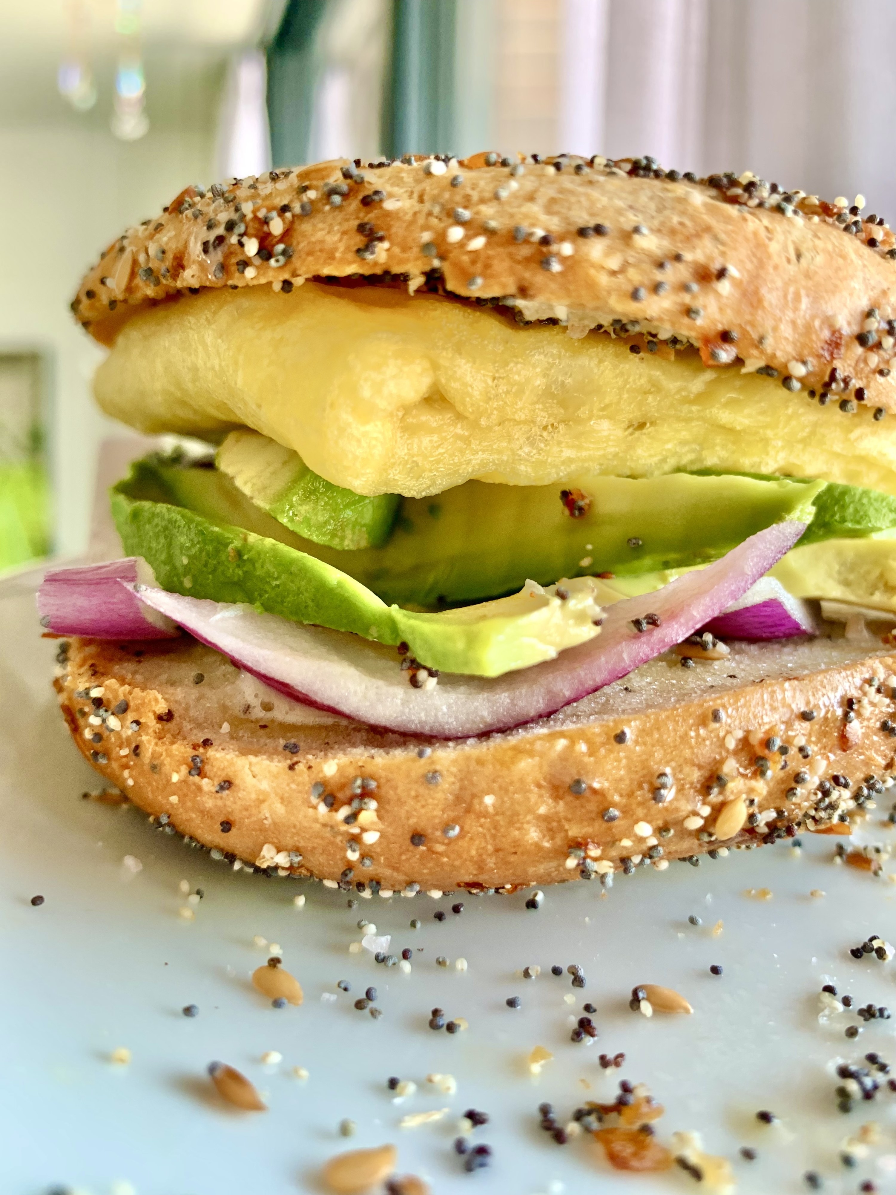 An everything bread sandwich with Just Egg, red onion, and avocado