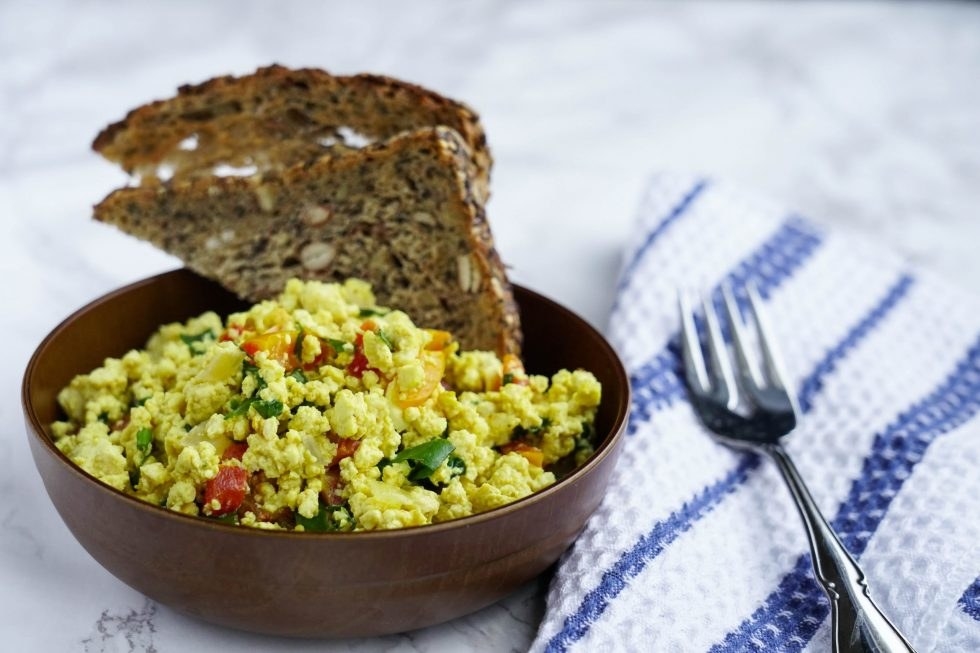 A bowl of tofu scramble with toast next to it