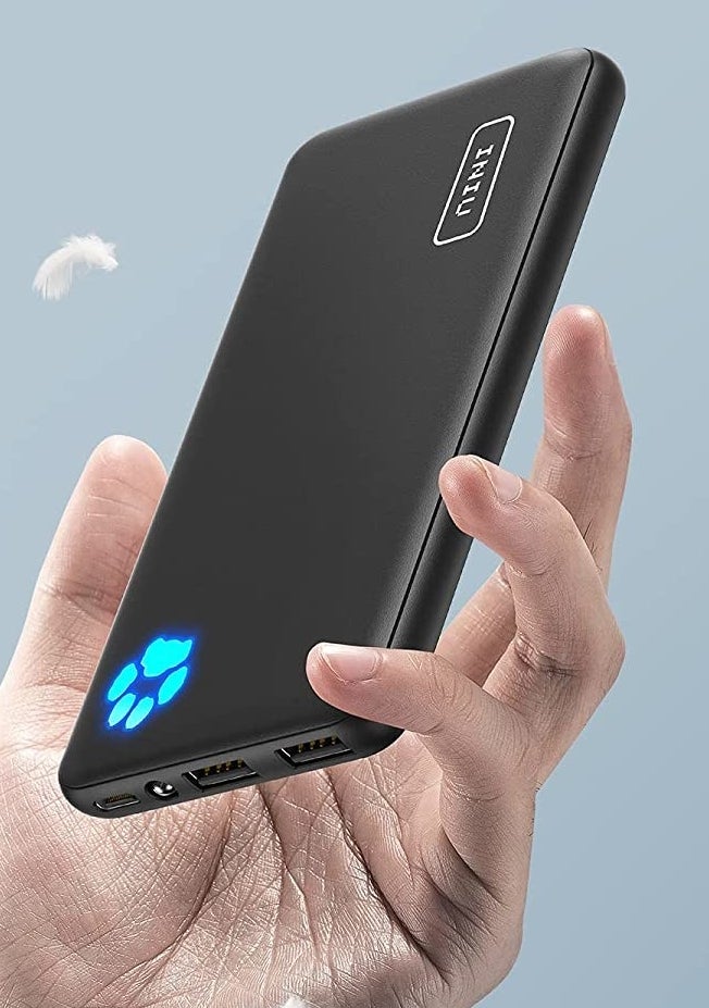 a person holding the portable charger against a plain background