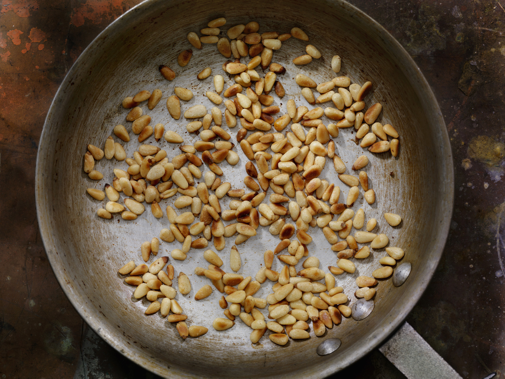 Toasted pine nuts in a skillet