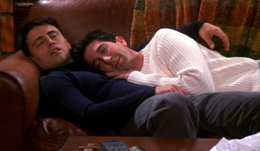 A close up of Joey Tribbiani and Ross Geller as they sleep cuddled on the couch