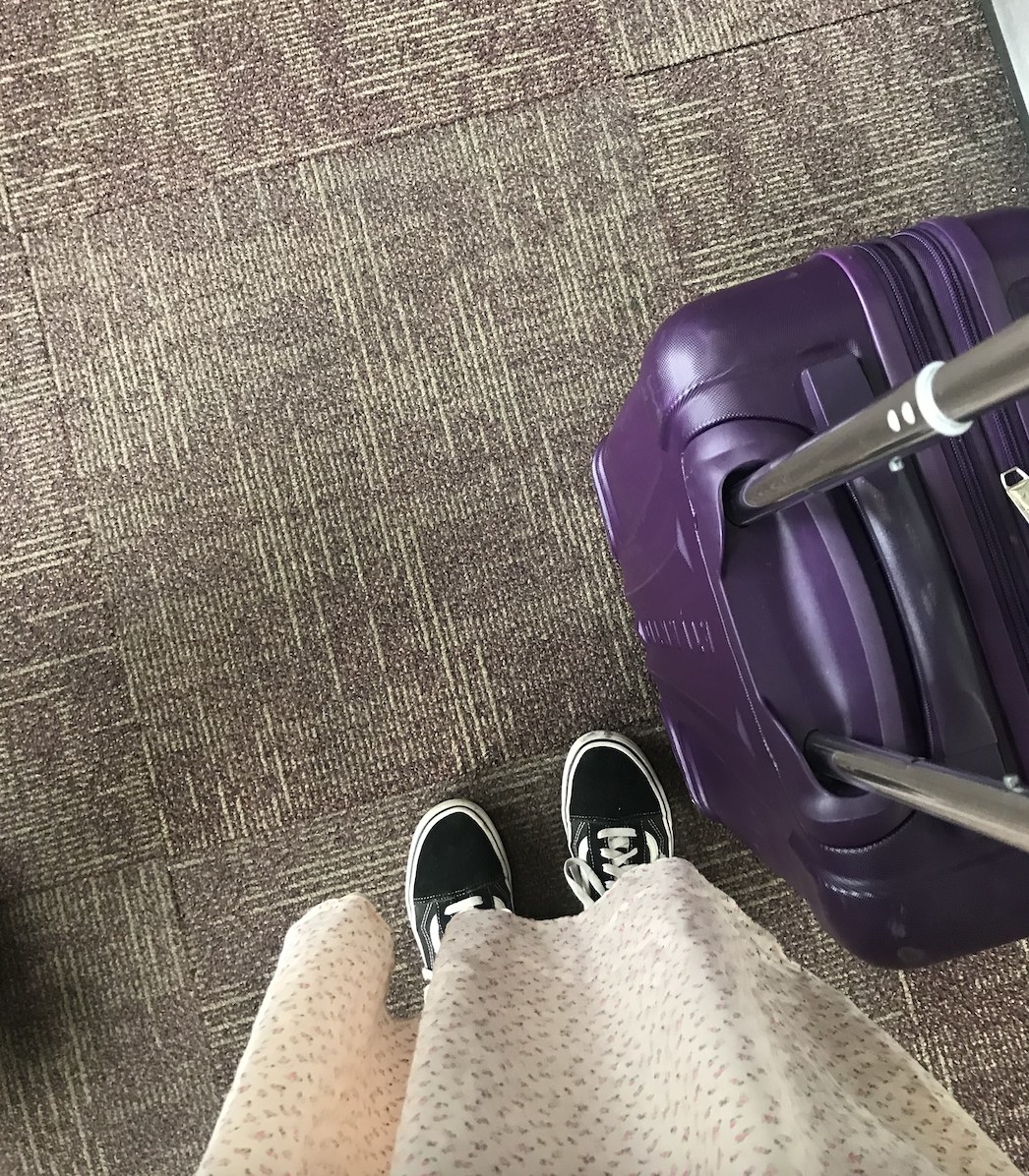 Feet and suitcase at the airport