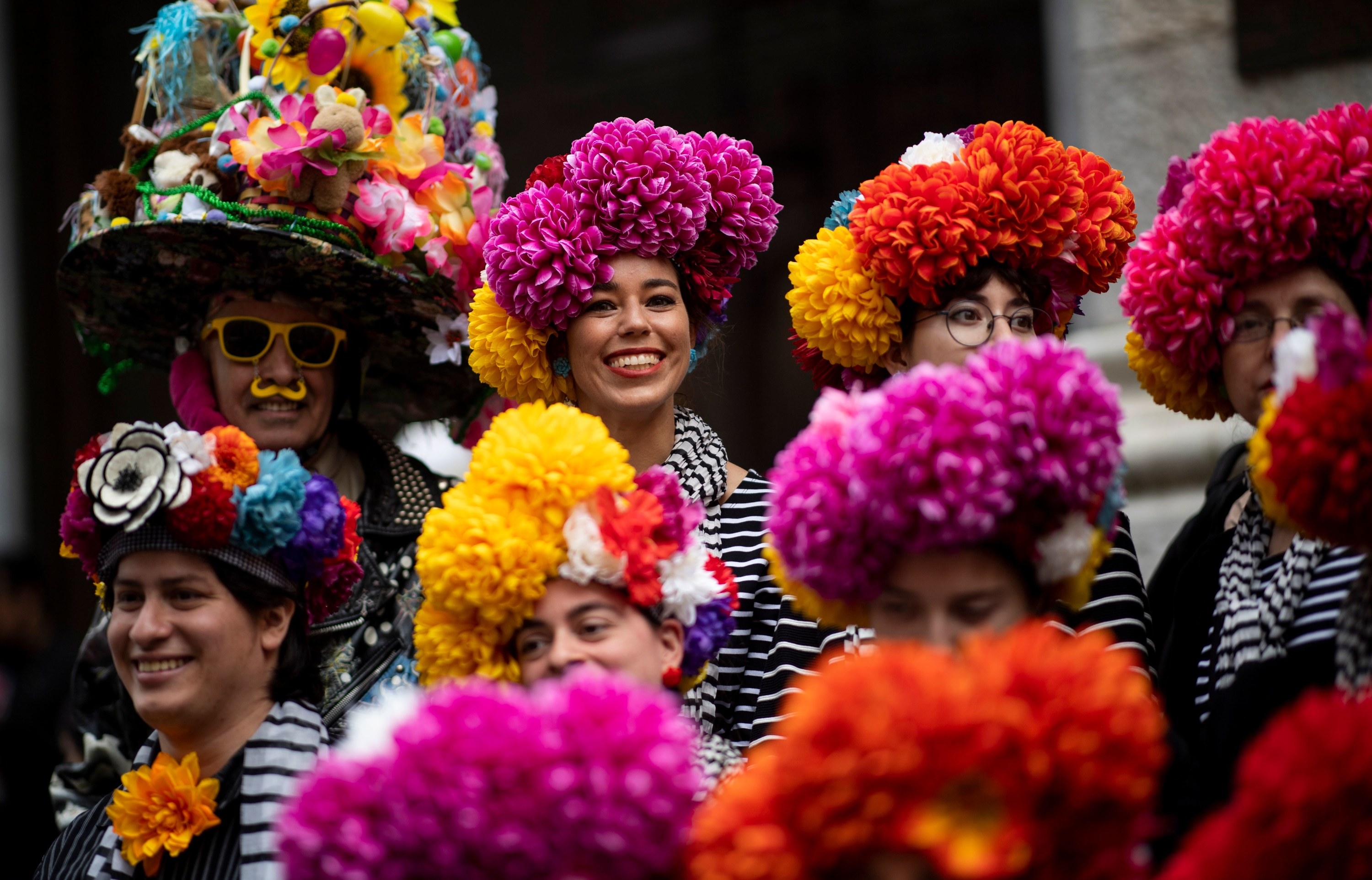 Smiling people with hats covered in flowers