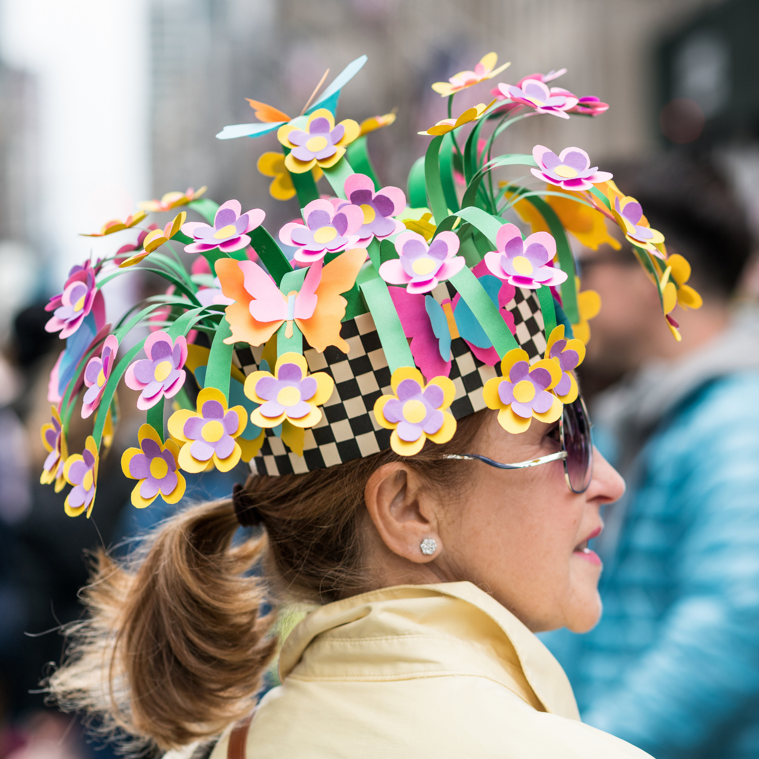 Close-up of colorful hat decorated with paper flowers worn by a woman