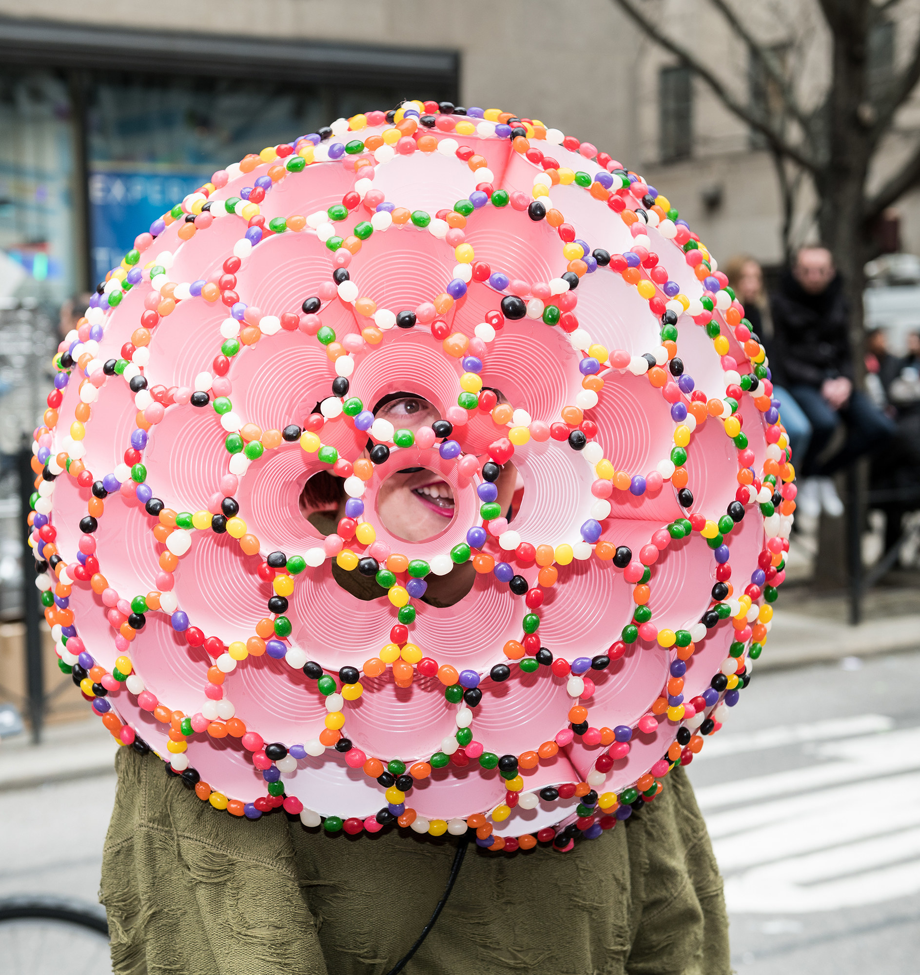 A peson wearing a hat made out of jellybeans and cups to look like a giant flower