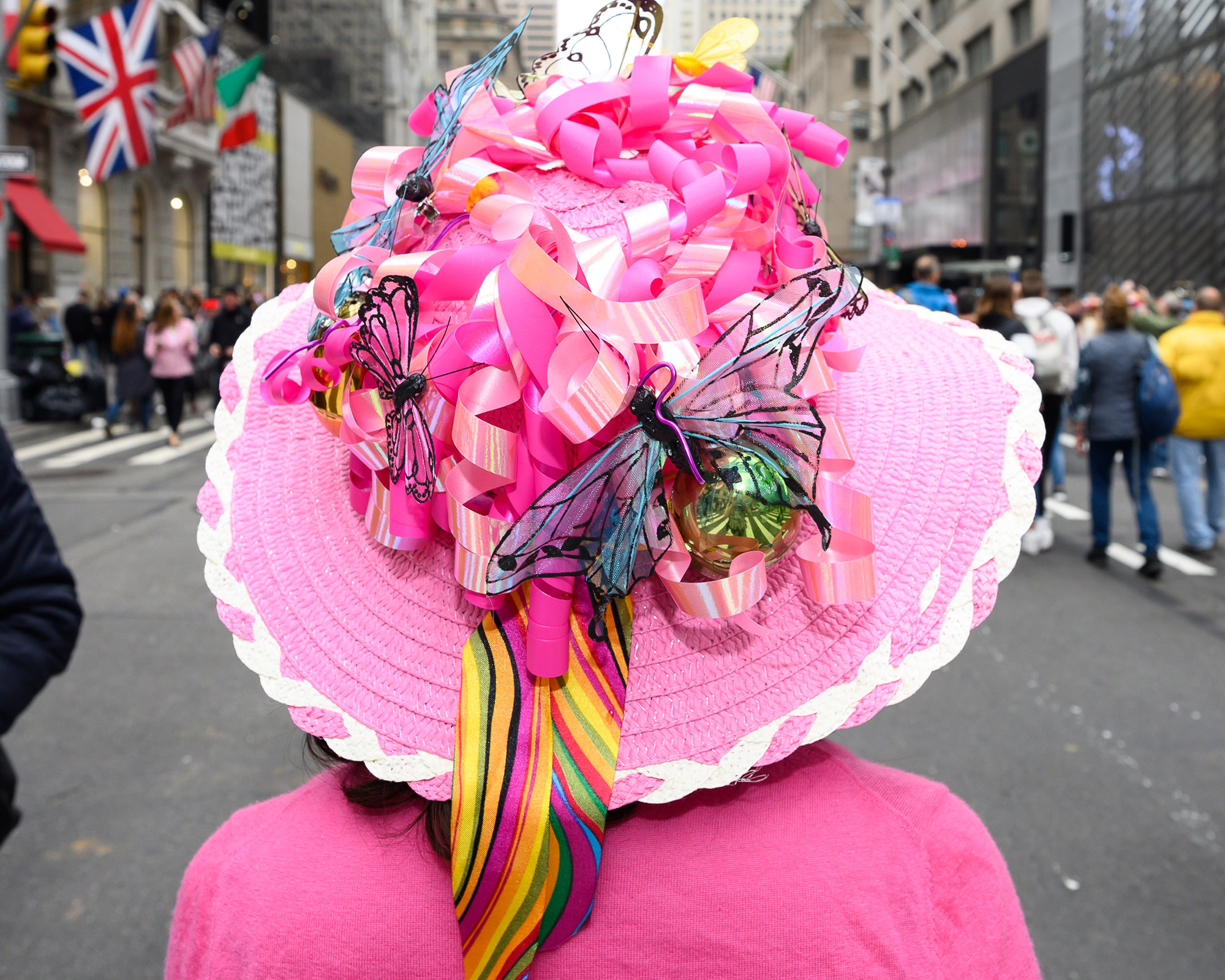 A woman with a large pink hat covered in ribbons