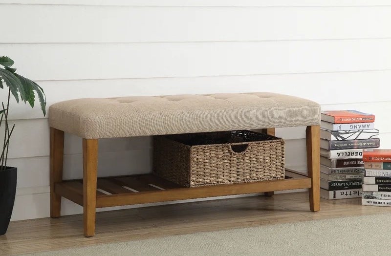 A wooden bench with a padded top and storage space.