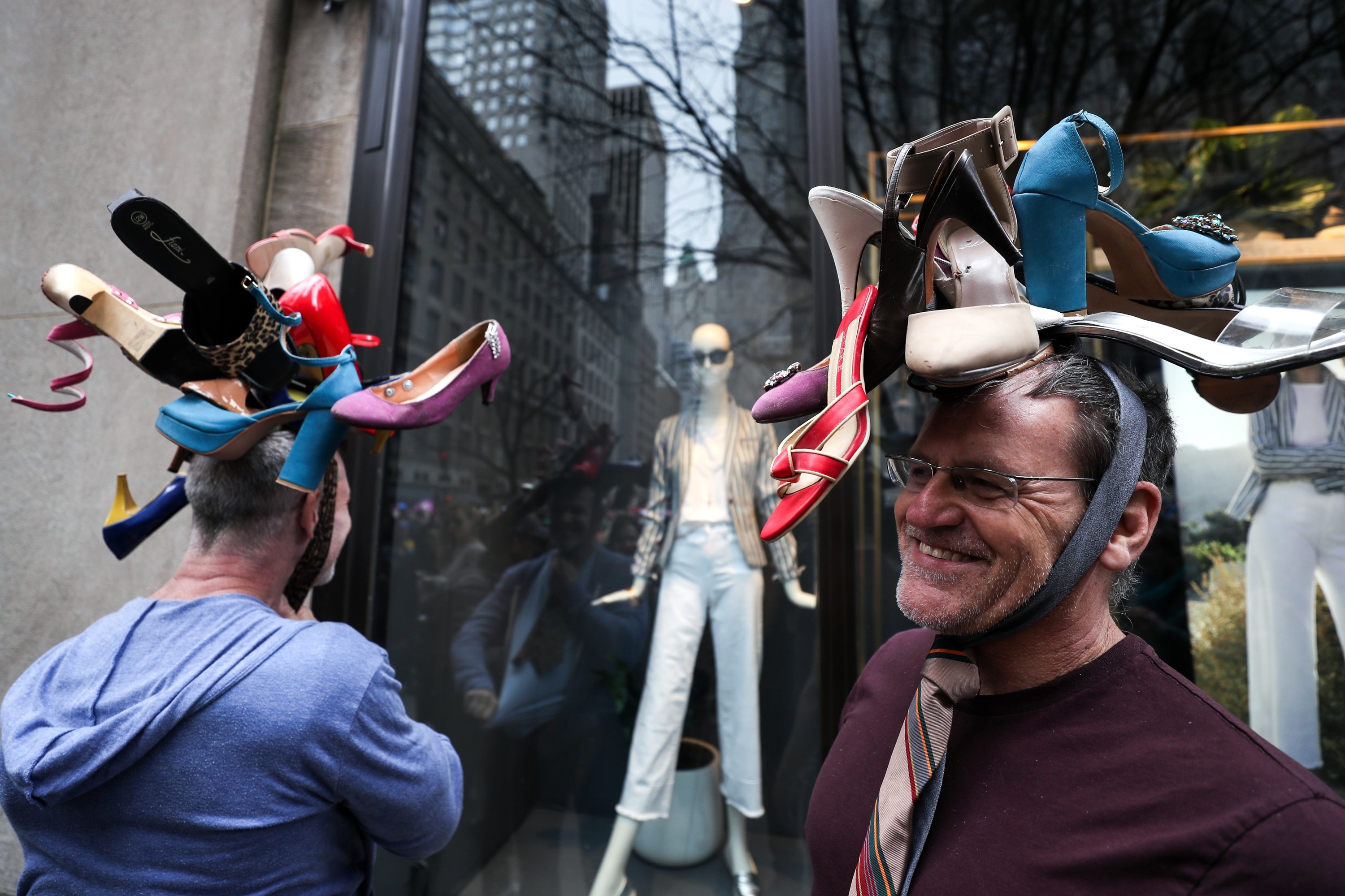 Men with hats covered in shoes smile