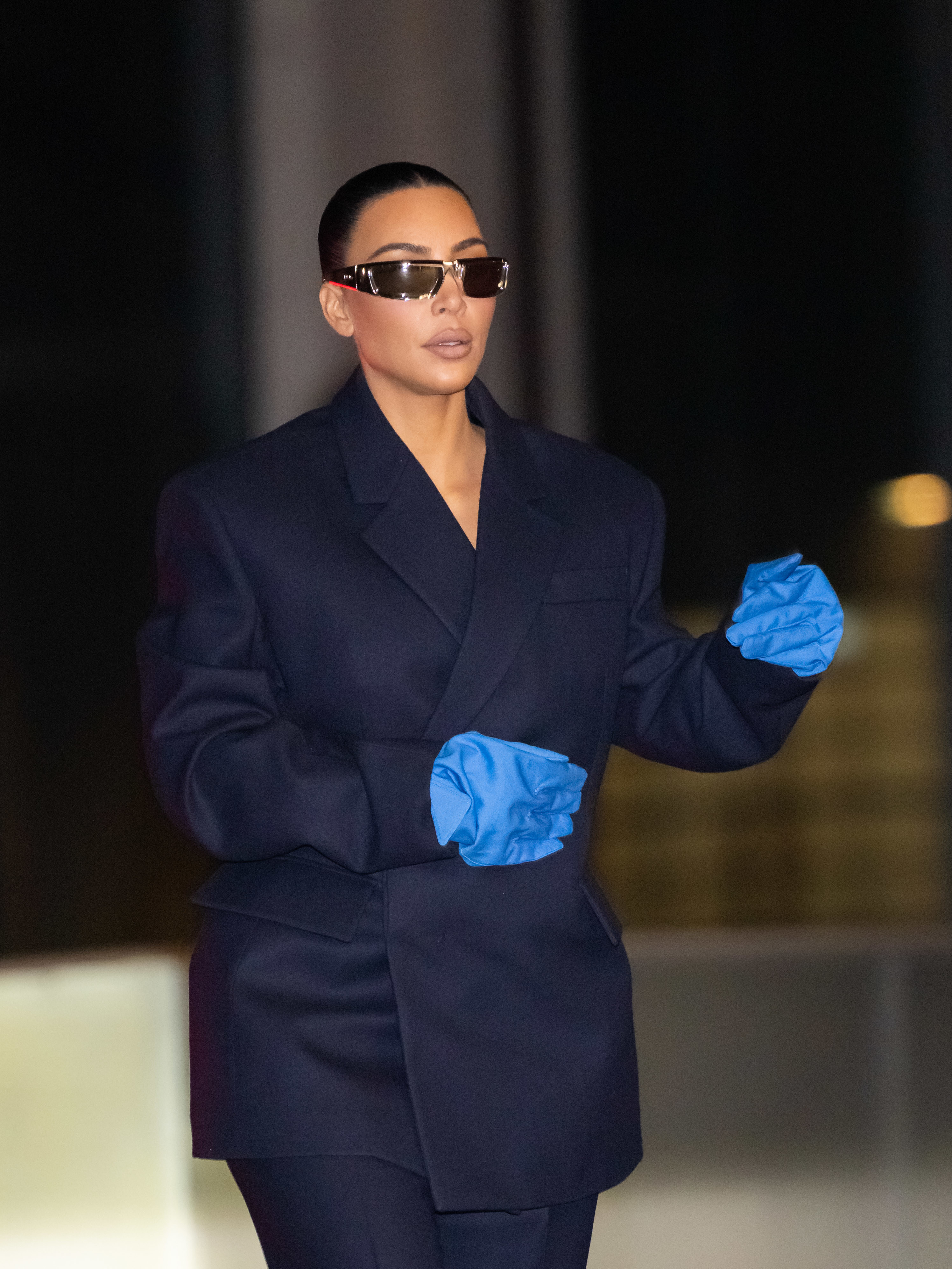 Kim wears gloves and sunglasses as she walks outside