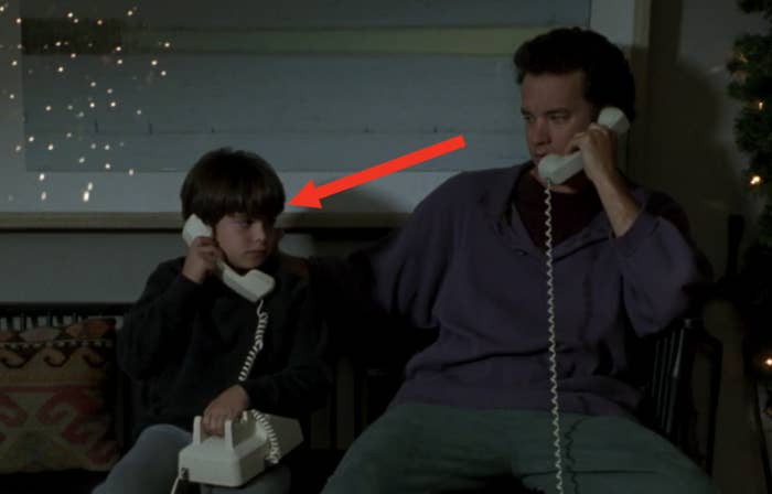 an arrow pointing to the new kid on the movie, sitting next to Tom Hanks as they both have a corded phone to their ears