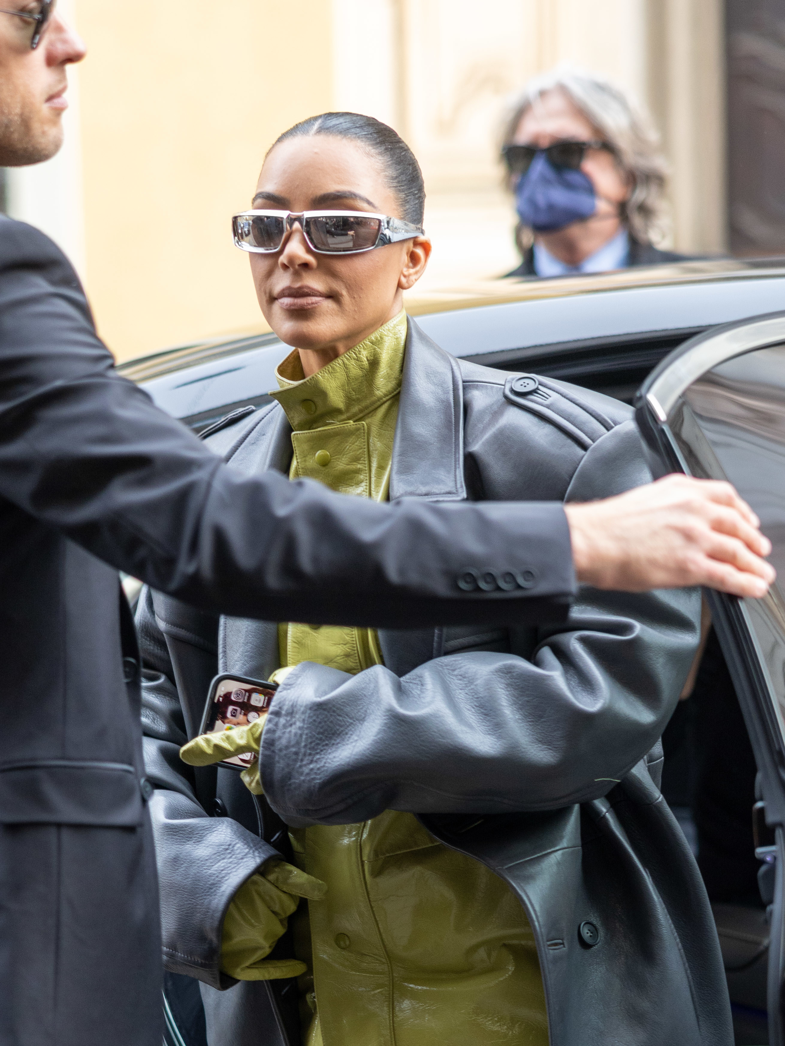 Kim holds her iPhone while stepping out of a car