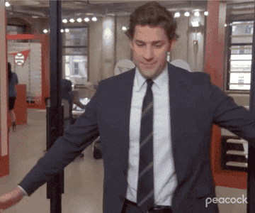 A gif of jim from the office doing a happy dance and spin