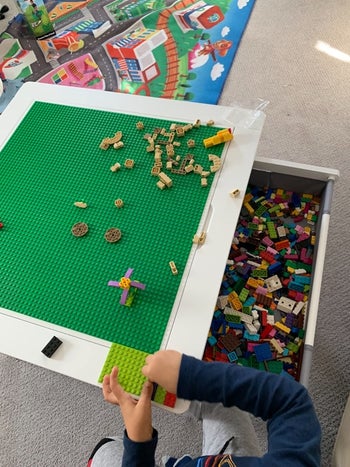 reviewer's photo of their child's Lego pieces stored in the white table