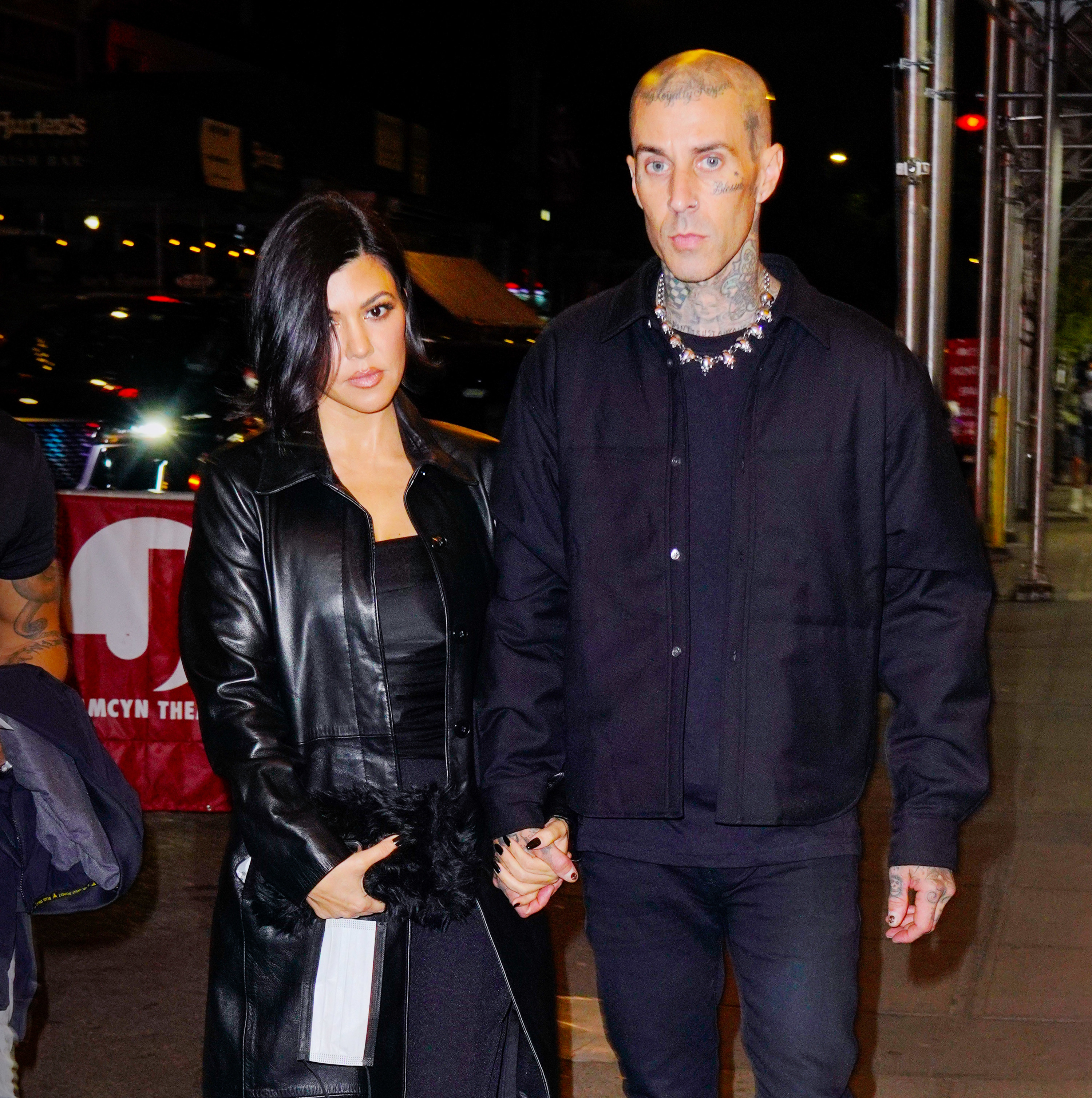 Kourtney holds Travis&#x27;s hand while walking down the street