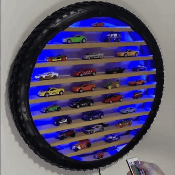 A gif of a hand changing the colors of the tire toy car organizer from blue to green
