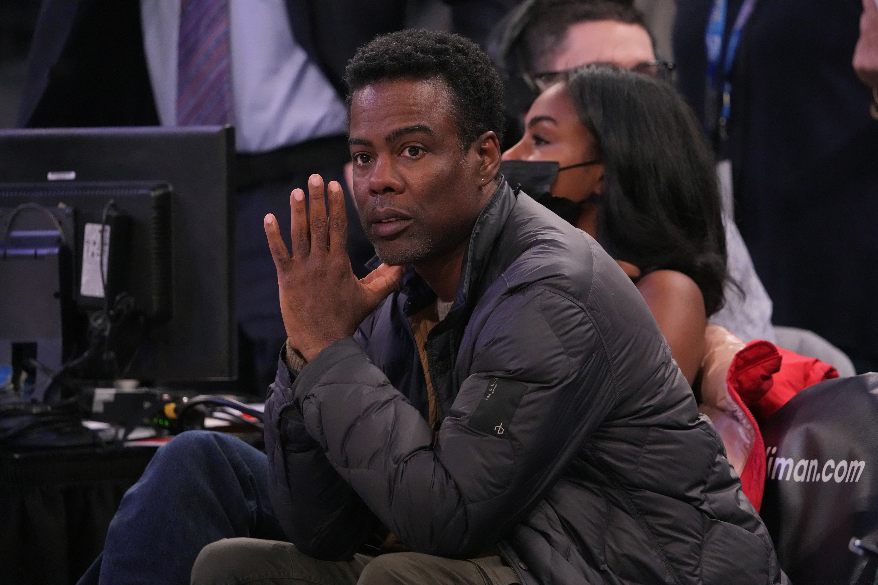 Chris sits courtside with his hands pressed together