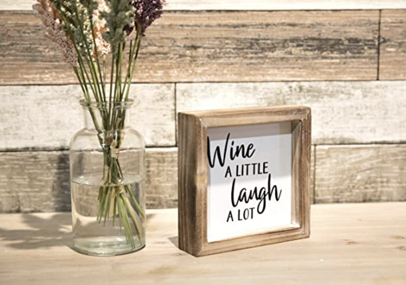 sign that reads, wine a little laugh a lot