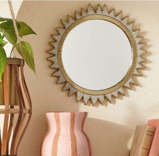 A brass sunburst mirror
