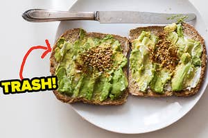 Two pieces of toast with smashed avocado sits on a plate
