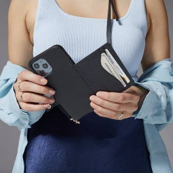 model holding the phone case, showing how the sleeve opens out and has two slots to hold cards