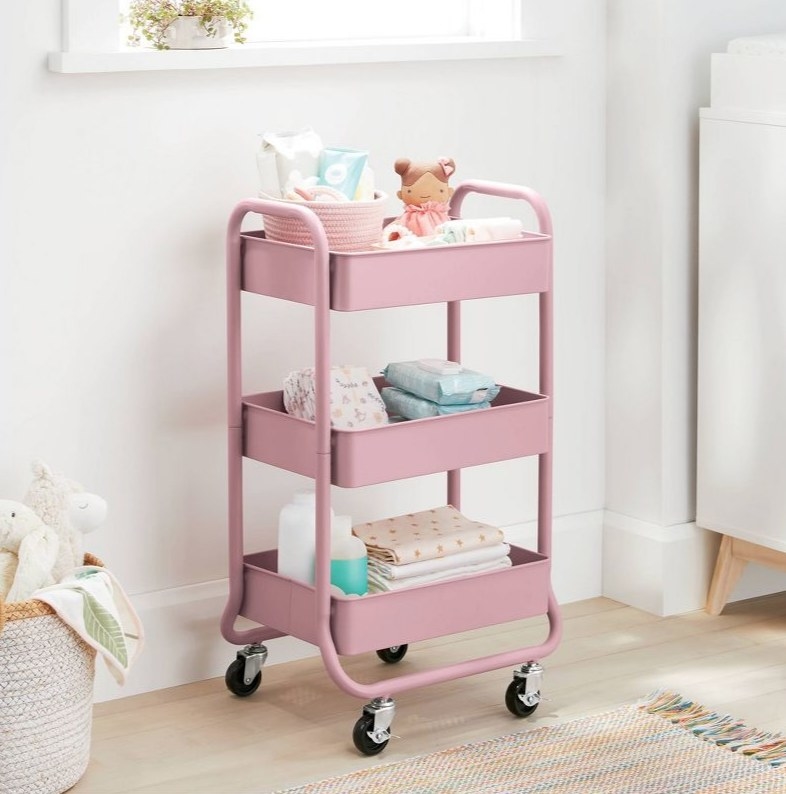 A pink three tier utility cart on wheels