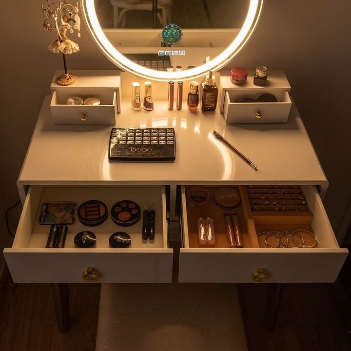 a close up of the vanity with its drawers open and makeup inside