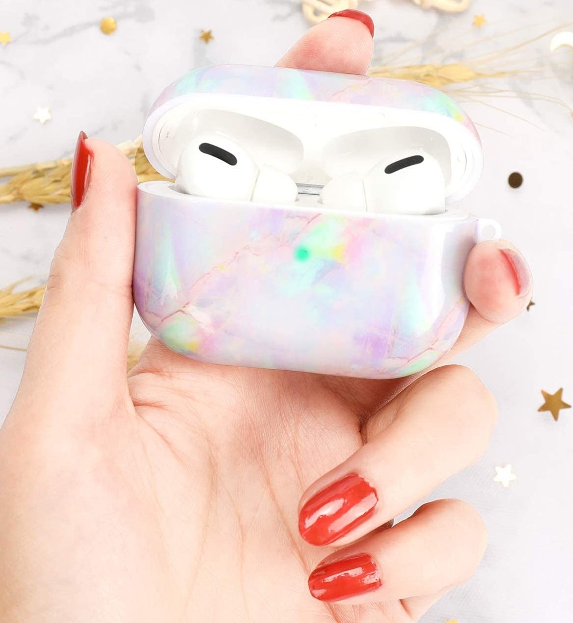 model&#x27;s hand holding the marble airpods case