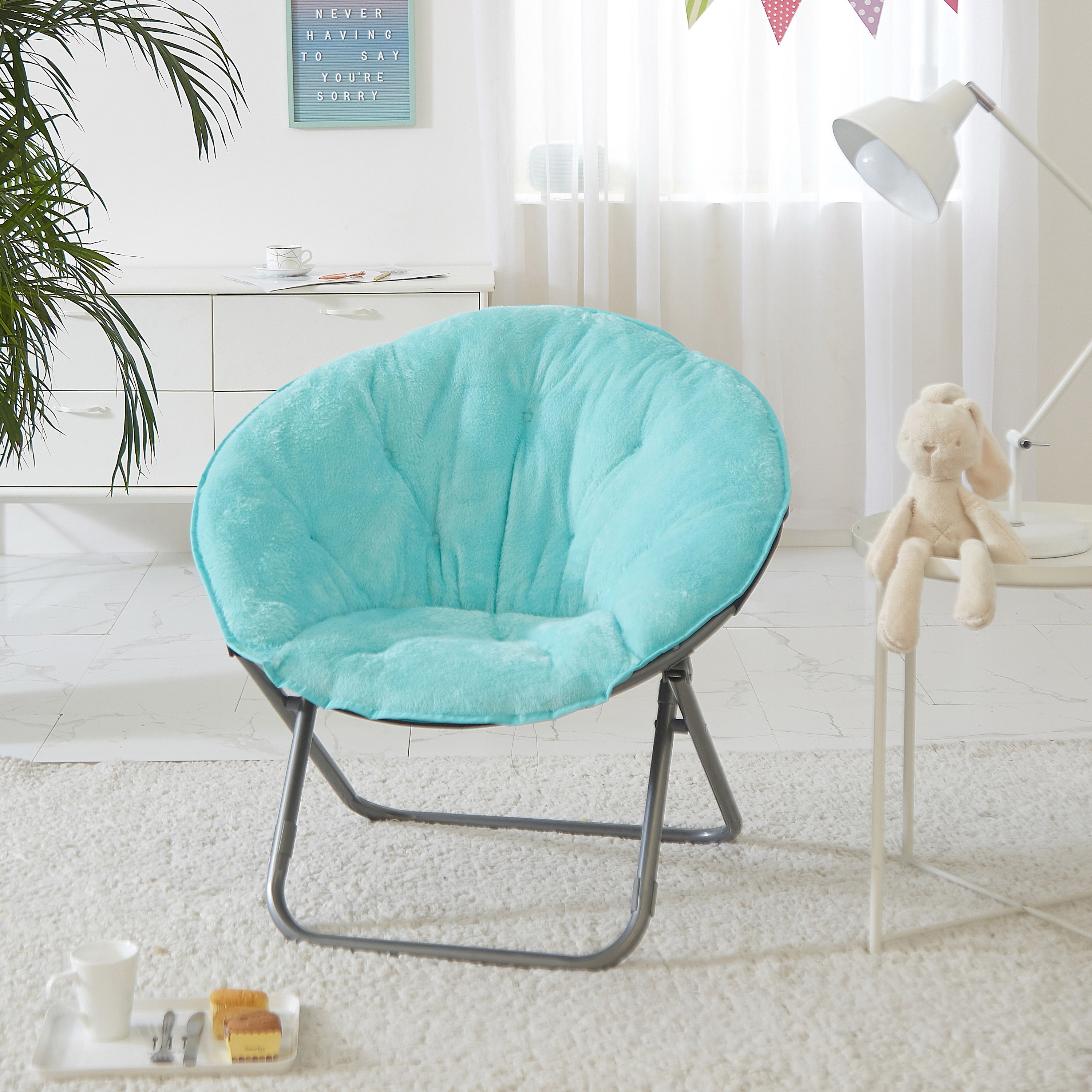 An image of a faux fur saucer chair with a soft wide seat and a foldable steel frame
