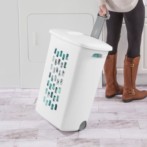 An image of a wheeled laundry hamper with a flip-top lid and retractable handle