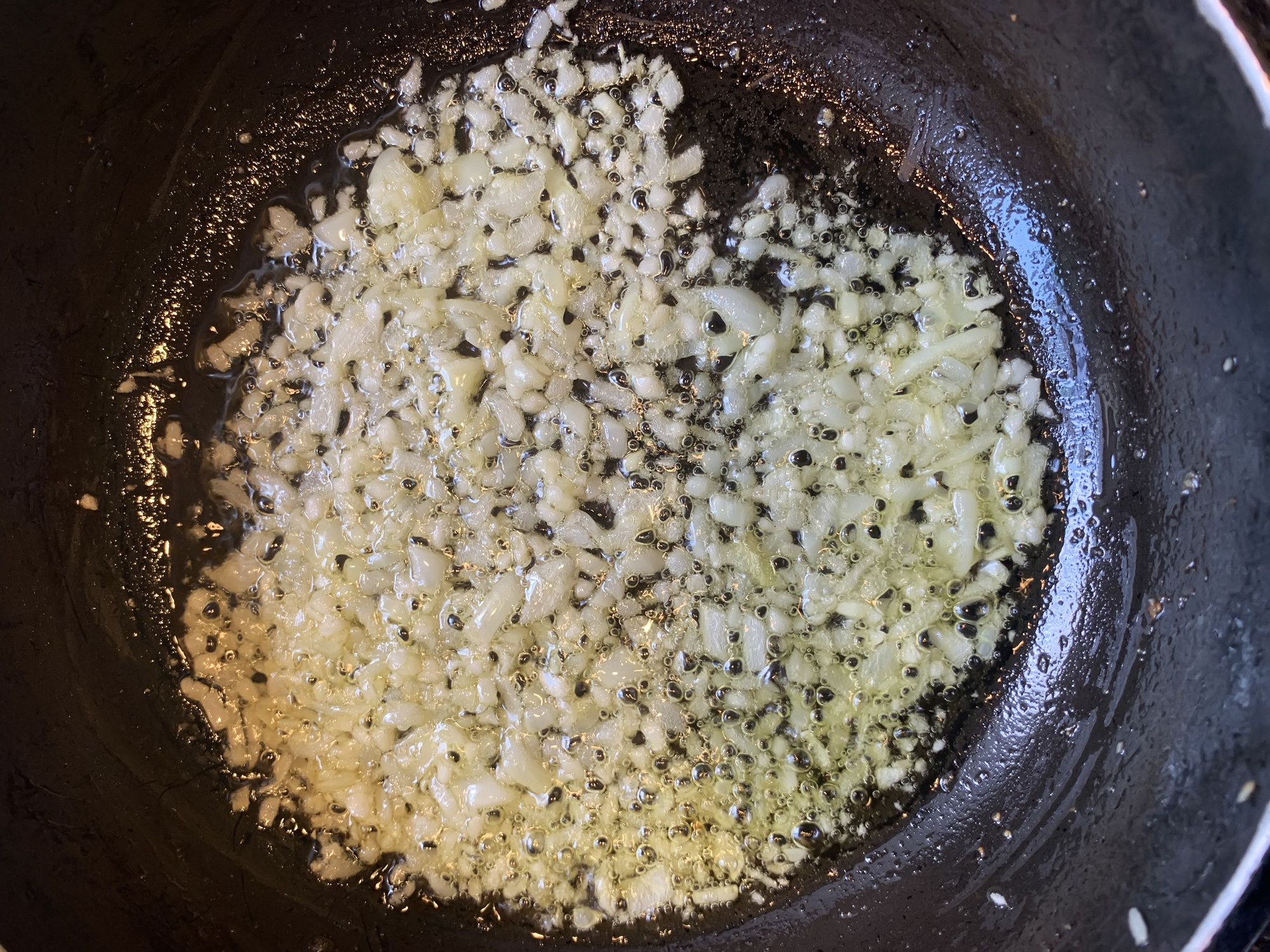 Minced garlic simmering in a pan.