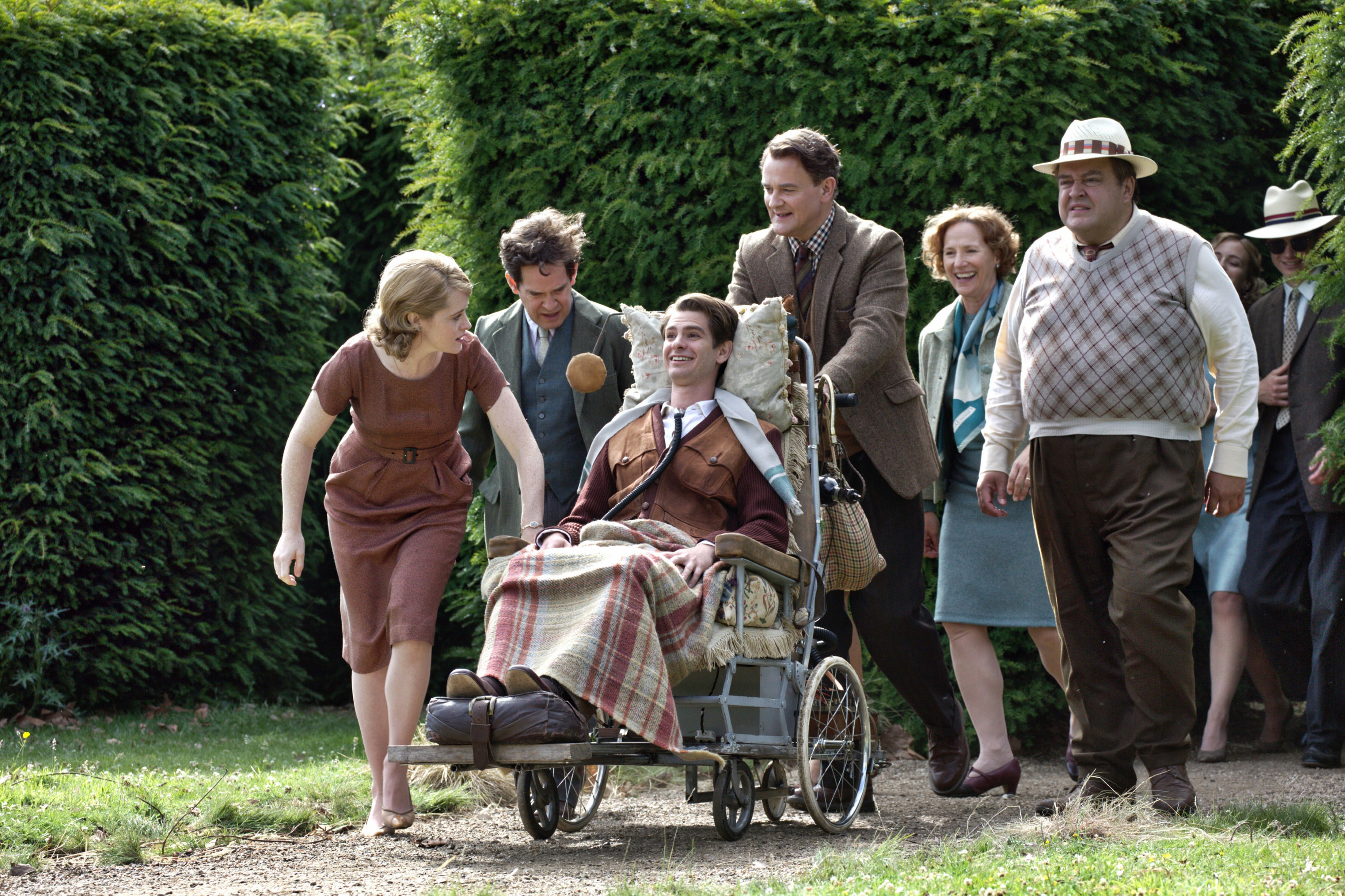 Claire Foy, Tom Hollander, and Hugh Bonneville push Andrew Garfield in a wheelchair