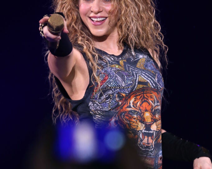 Shakira pointing her mic and smiling