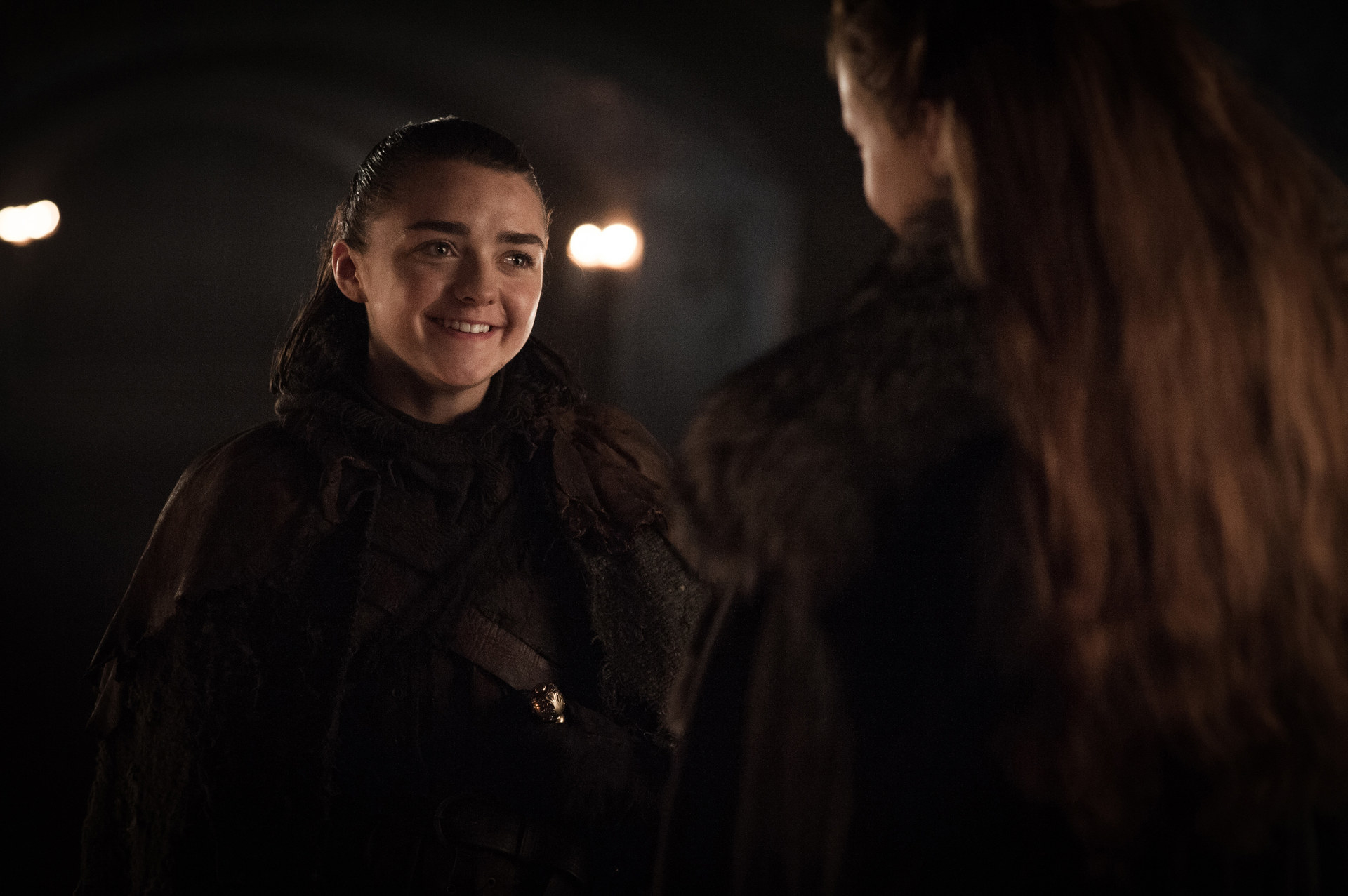Arya smiles while talking to her sister played by Sophie Turner