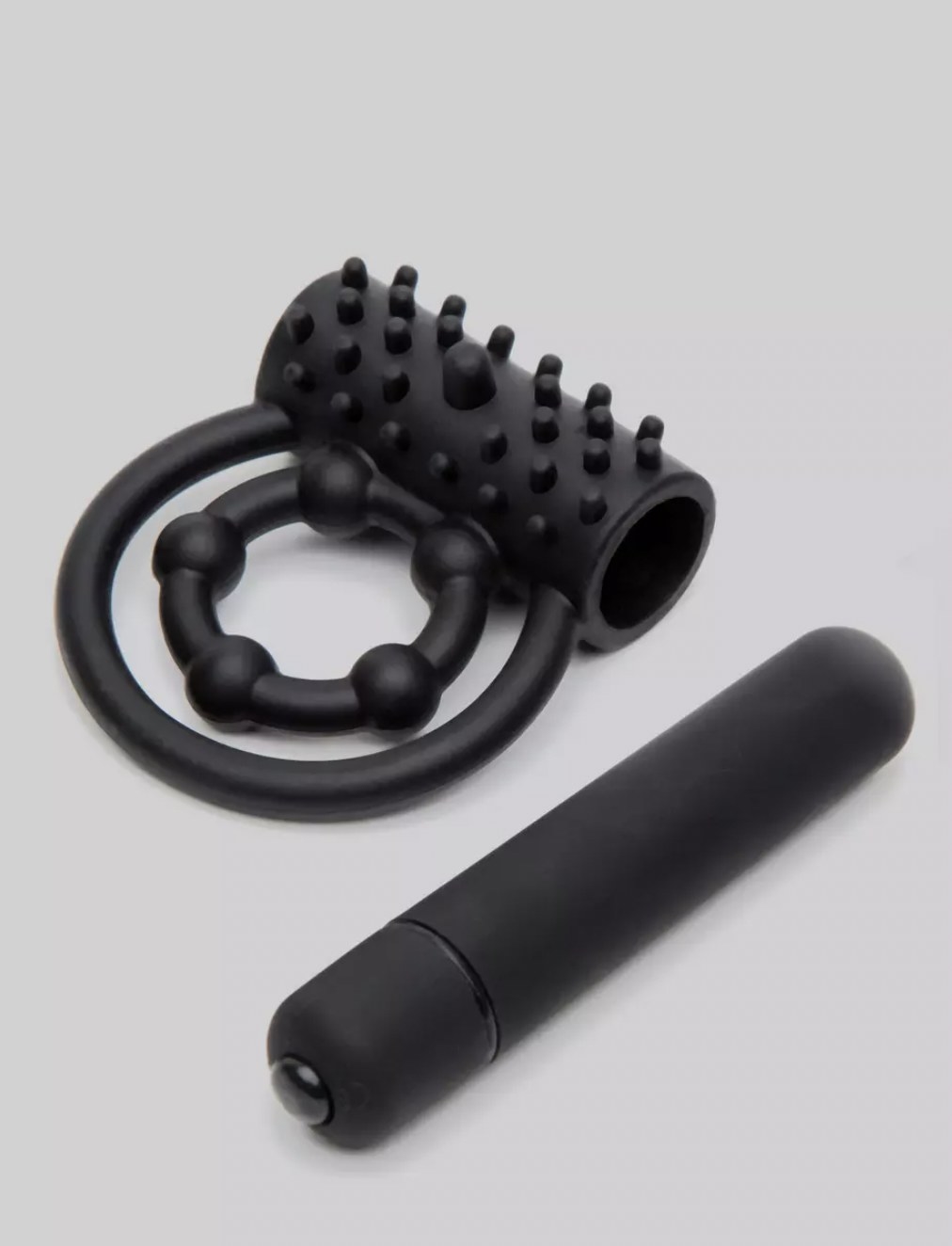 the dual cock ring with bullet vibe removed and laying next to it